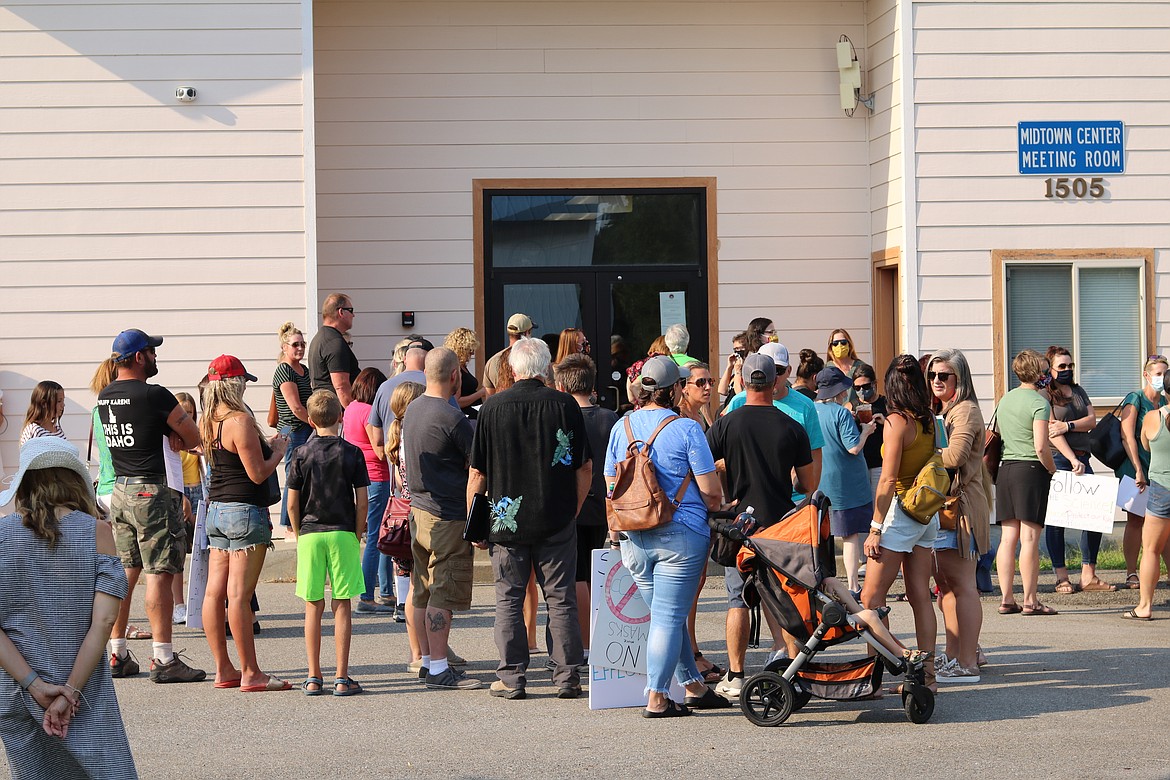 A crowd of parents, students and community members, some carrying signs stating their view on mask mandating, gathered outside the Midtown Center Meeting Room to attend the special meeting of the Coeur d’Alene School District Board of Trustees on Monday evening. HANNAH NEFF/Press