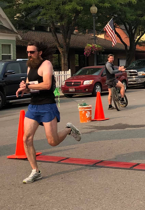 Eli Bourgard checks his time as he crosses the finish line of the Huckleberry Festival's 5K Fun Run.