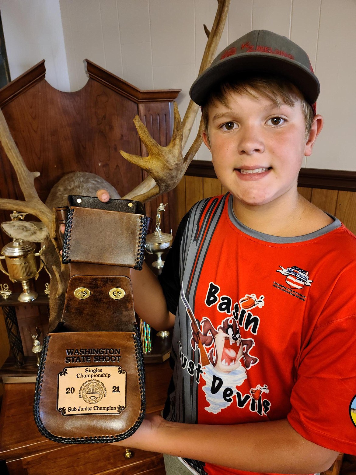 Travis Shearer displays one of his awards from a trapshooting competition.