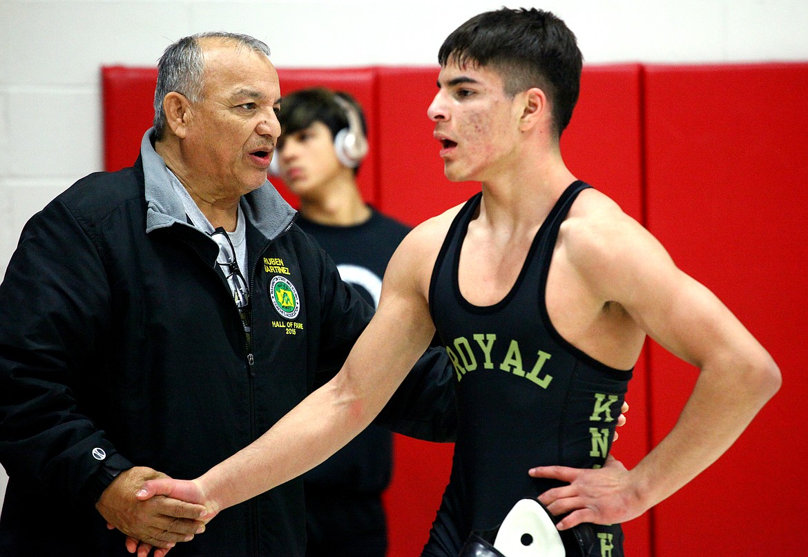 Legendary wrestling coach Ruben Martinez shakes the hand of sophomore Dominic Martinez after his match at the Leonard Schutte tournament.