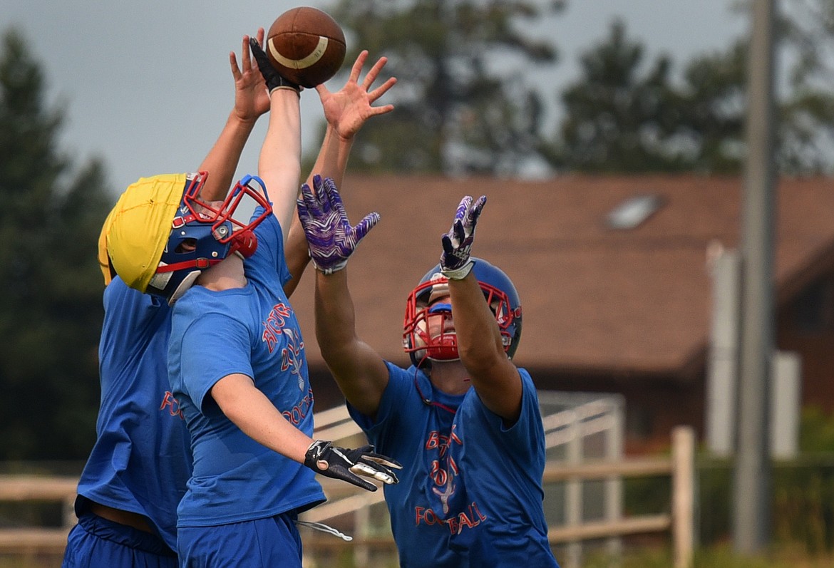 Two defenders knock down a pass from a would-be receiver during seven-on-seven drills at the Vikings first football practice Friday. (Jeremy Weber/Bigfork Eagle)