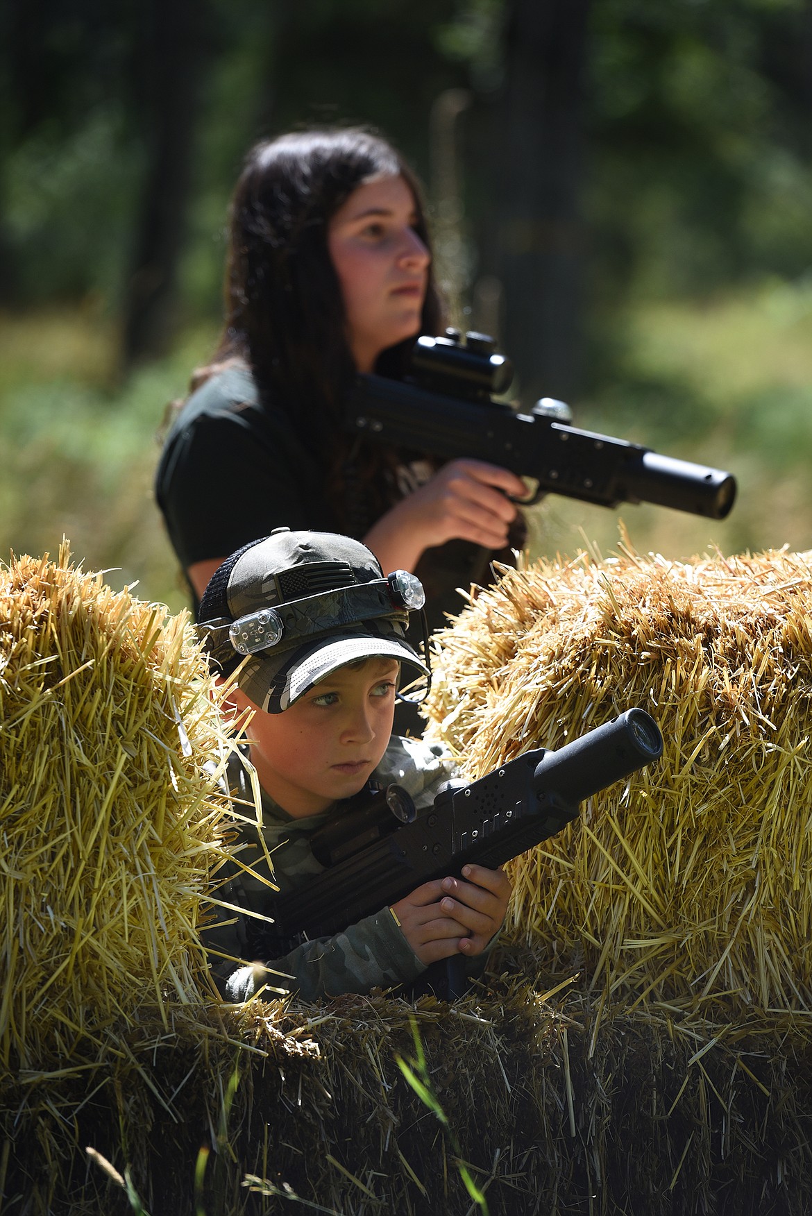 Alexa Blumenthal, top, and Aiden Hickey look for targets while playing with Flashpoint Outdoor Laser Tag near Bigfork on Friday, Aug. 10, 2021. (Jeremy Weber/Daily Inter Lake)