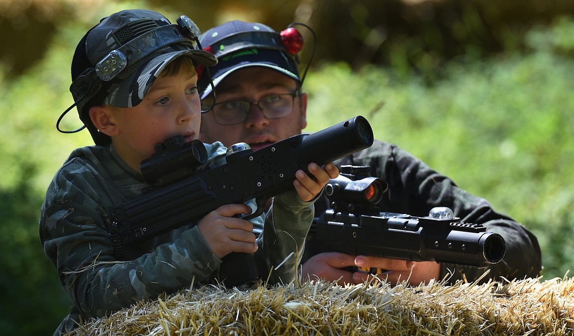 Ethan Hickey, right, and his son Aiden strategize while playing laser tag with Flashpoint Outdoor Laser Tag near Bigfork on Friday, Aug. 10, 2021. (Jeremy Weber/Daily Inter Lake)