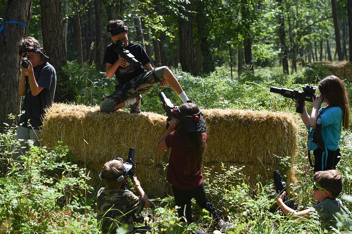 Laser tag players battle for control of a hay bale while playing with Flashpoint Outdoor Laser Tag near Bigfork on Thursday, Aug. 19, 2021. (Jeremy Weber/Daily Inter Lake)