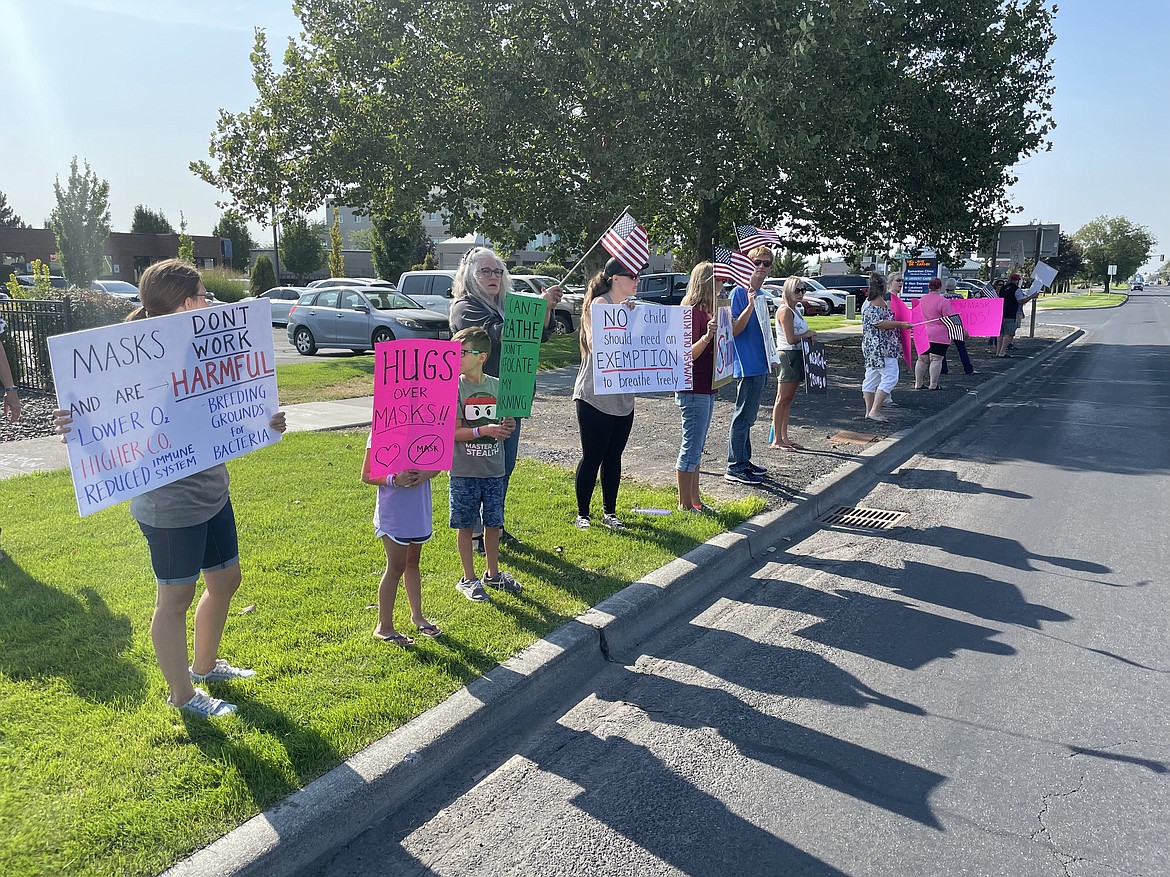 People line South Pioneer Drive Wednesday evening to protest Gov. Jay Inslee’s vaccine mandate, which he expanded to include teachers, as well as the mask mandate for public school students.