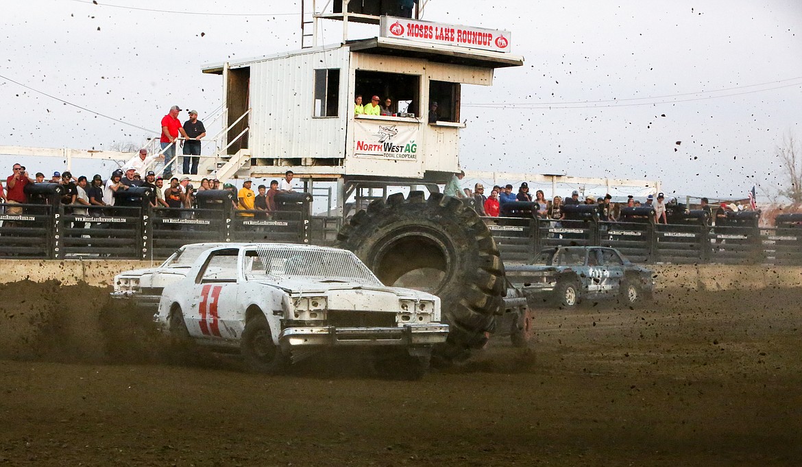 A tractor tire is flung into the air as drivers round the corner during a race event at the Northwest Ag Demolition Derby on Wednesday night.