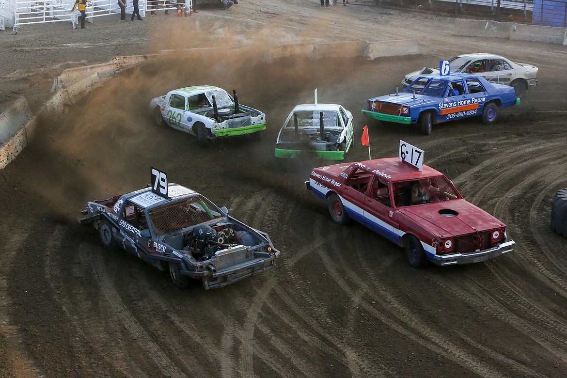 Cars round the corner on the track during a heat race on Wednesday at the Northwest Ag Demolition Derby.