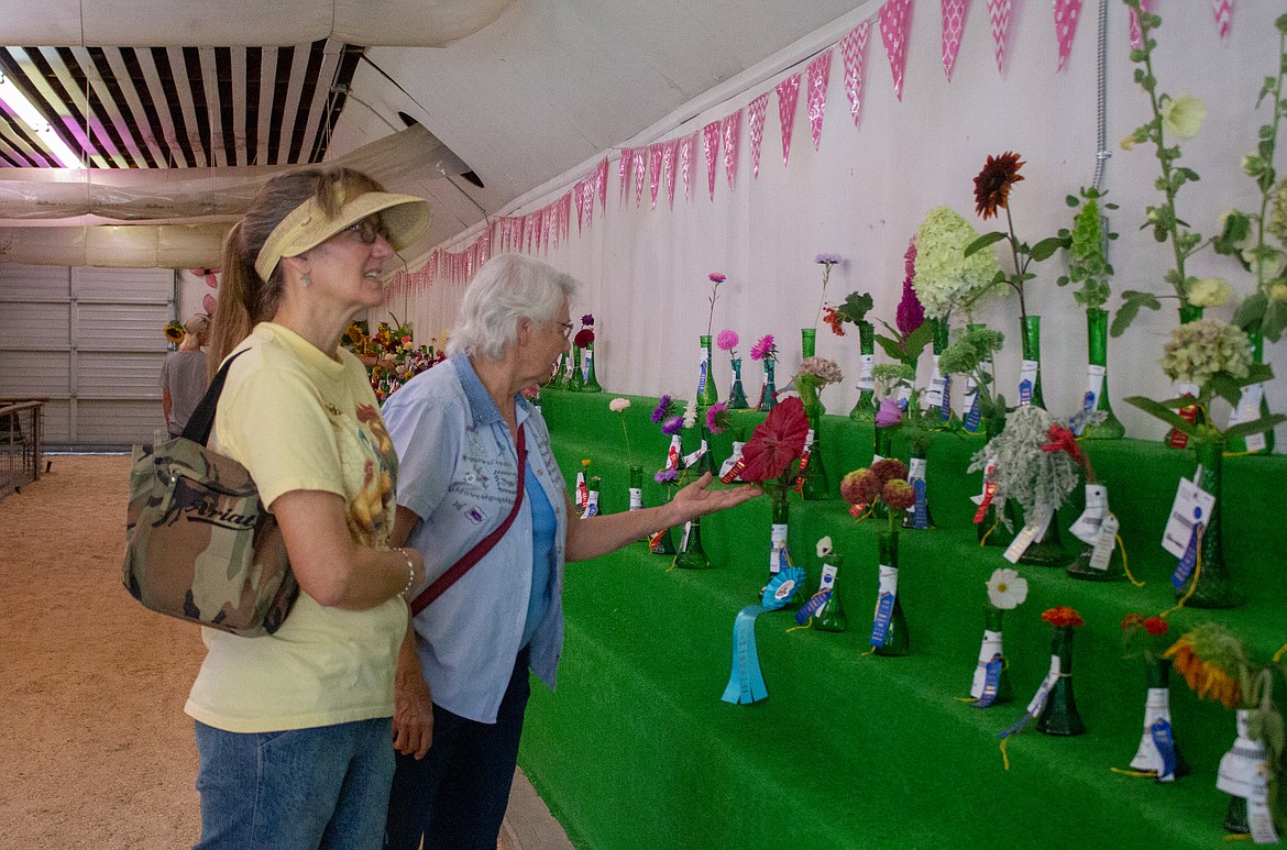 Left to right, Melanie Pearce and Judy Hirschel browse the flowers on display in the Flower Building at the Grant County Fairgrounds on Wednesday afternoon.