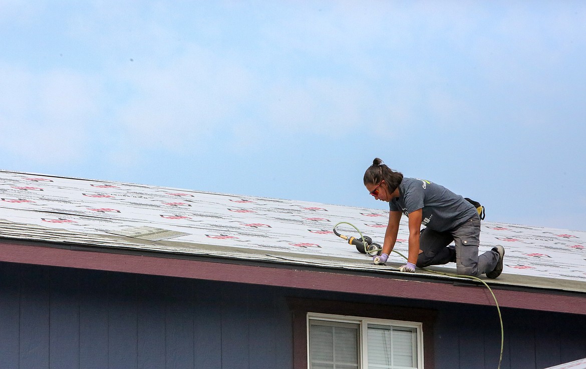 Nelly Ortega with Guardian Roofing & Exteriors puts on a new shingled roof outside of Moses Lake on Thursday morning.