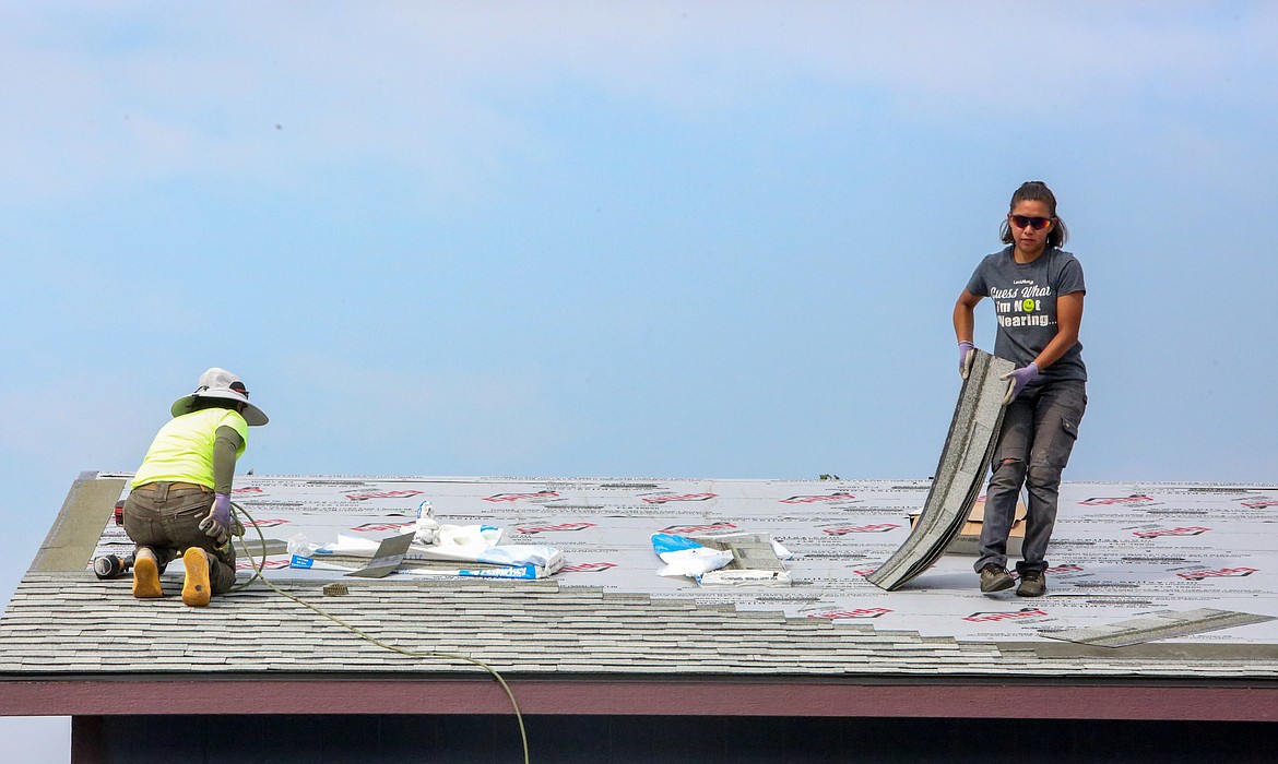 Left to right, Patricia Ortiz and Nelly Ortega with Guardian Roofing & Exteriors put on a new shingled roof outside of Moses Lake on Thursday morning.