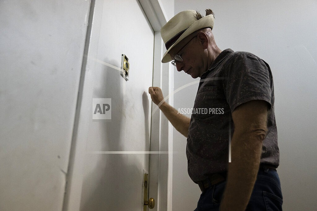 Gary Zaremba knocks on an apartment door as he checks in with tenants to discuss building maintenance at one of his at properties, Thursday, Aug. 12, 2021, in the Queens borough of New York. Landlords say they have suffered financially due to various state, local and federal moratoriums in place since last year. “Without rent, we’re out of business," said Zaremba. (AP Photo/John Minchillo)