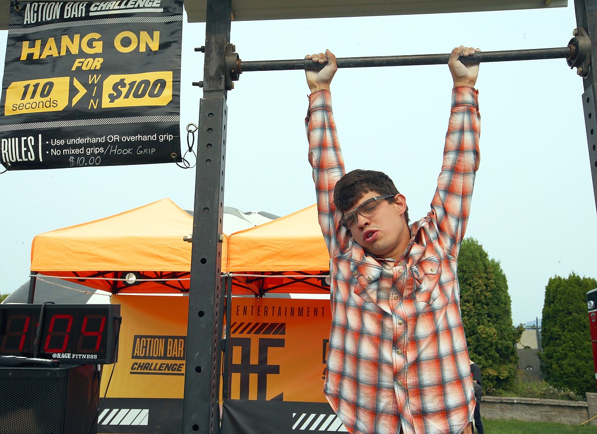 Montana Rice of Coeur d’Alene tests his ability to hang as he tries the Action Bar Challenge at the North Idaho State Fair on opening day Friday.