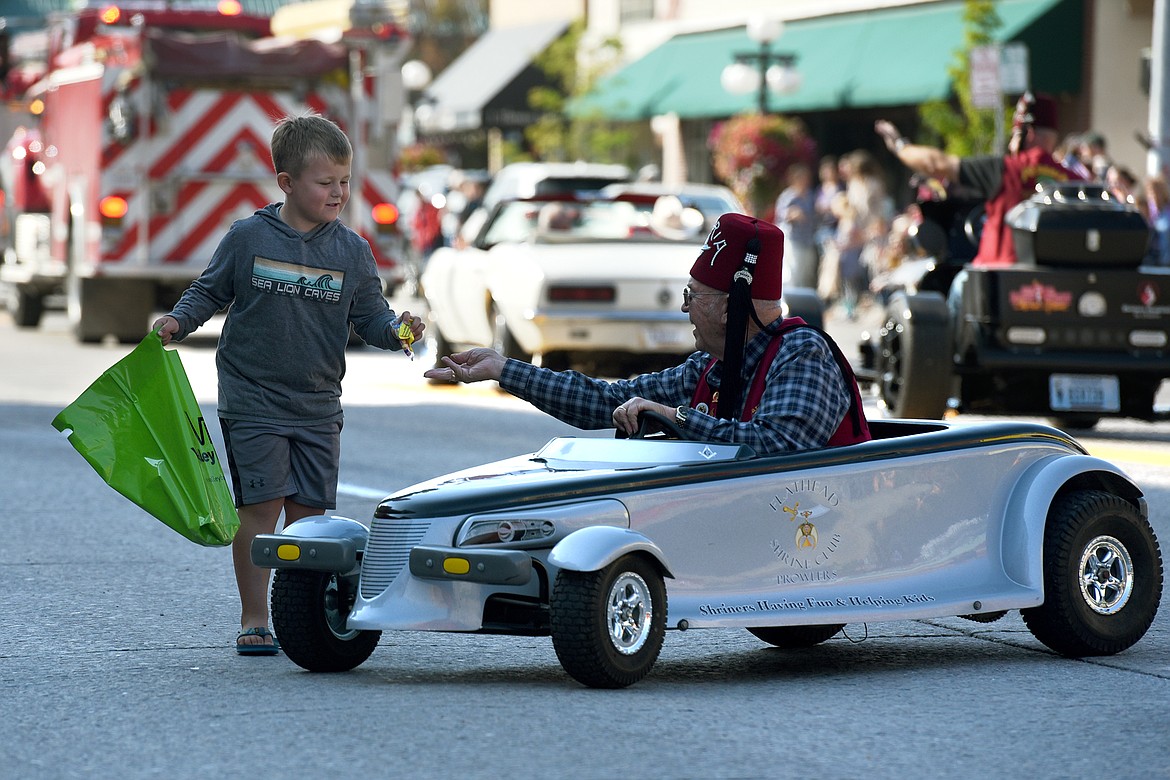 A member of the Flathead Shriners Club Prowlers hands out candy during the Northwest Montana Fair Parade on Main Street in Kalispell on Friday, Aug. 20, 2021. (Jeremy Weber/Daily Inter Lake)