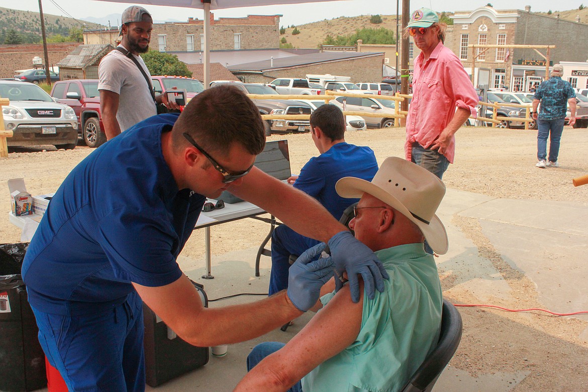 Kyle Austin, a pharmacist who started a mobile clinic during the pandemic, administered 20 covid vaccines on a recent Saturday in Virginia City, a town of roughly 120 year-round residents. His business model is to collect
vaccine stragglers as he makes a circuit through Montana. (Katheryn Houghton/KHN)
