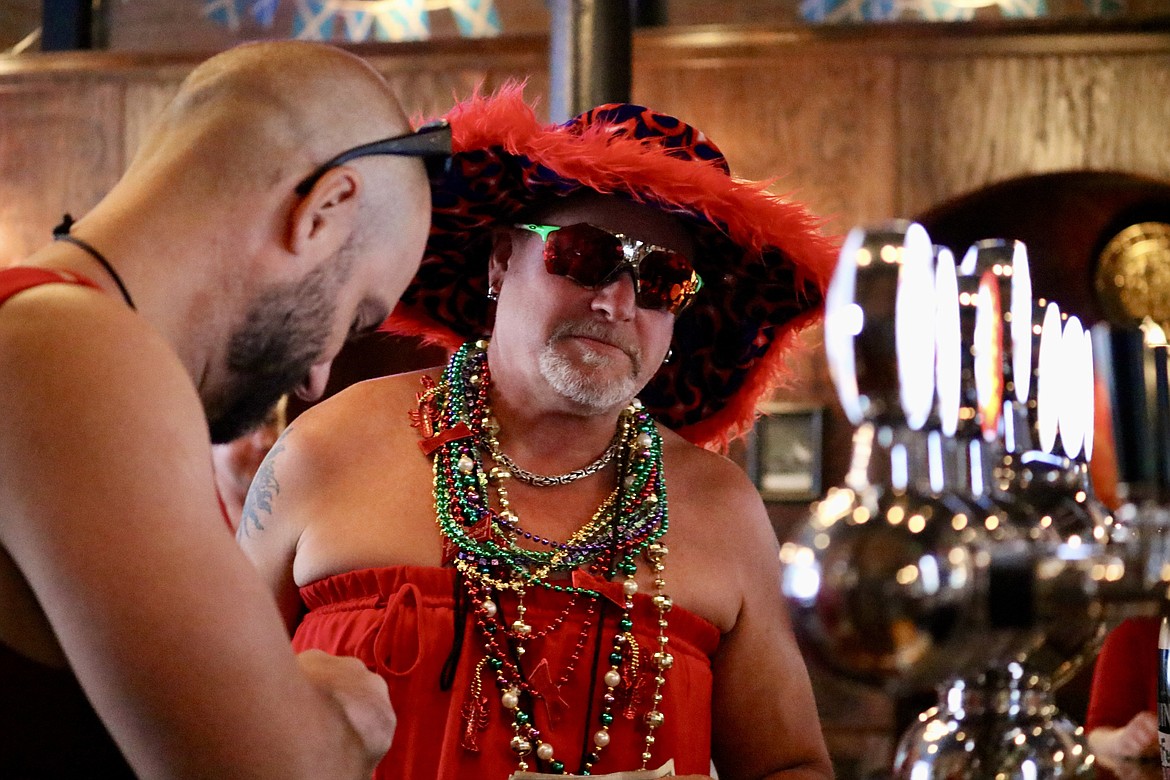 Andrew Stratton buys a beer in the Crown & Thistle Pub on the first beer stop for the Red Dress Run on Saturday afternoon, an annual charity fundraiser put on by the Coeur d'Alene Hash House Harriers. HANNAH NEFF/Press