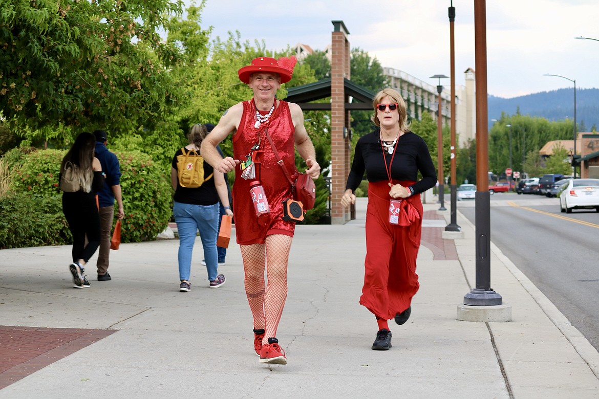 Mark Enegren, left, and David McDonald, members of the Coeur d'Alene Hash House Harriers, jog through downtown Coeur d'Alene during the seventh annual Red Dress Run for charity on Saturday evening. HANNAH NEFF/Press