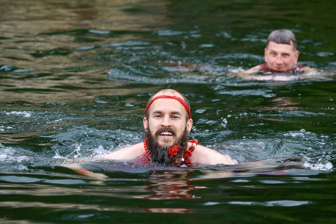 Ezra Sears, left, the hare, swims from Mark Enegren in the annual hounds and hares styled Red Dress Run charity fundraiser through downtown Coeur d'Alene on Saturday afternoon. HANNAH NEFF/Press