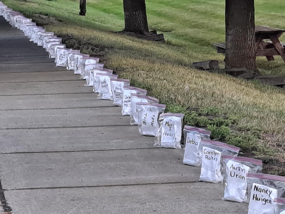 Luminarias line the sidewalk in Plains last weekend. The displays honored those who have endured cancer or died from the disease. (Adam Lindsay/Valley Press)