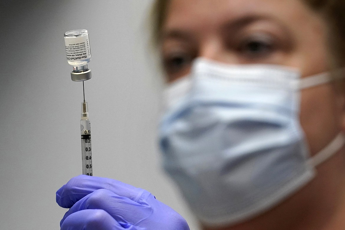 In this March 2, 2021, file photo, pharmacy technician Hollie Maloney loads a syringe with Pfizer's Covid-19 vaccine at the Portland Expo in Portland, Maine. The U.S. gave full approval to the Pfizer vaccine on Monday, Aug. 23, 2021. (Robert F. Bukaty/Associated Press)