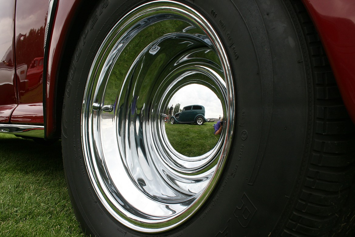 A 1934 Ford is reflected in the hubcap of a 1947 Ford at the Hot August Nights car show Saturday at Smokiam RV Resort in Soap Lake.