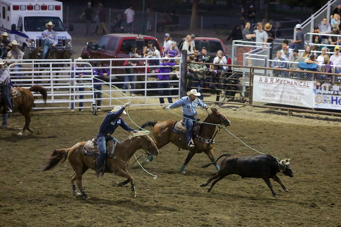 Kellan and Carson Johnson of Casper, Wyoming, compete in the team roping event Saturday night at the Moses Lake Roundup rodeo.