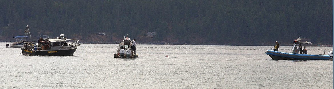 Kootenai County Sheriff's boats are joined by a diver as they search for the body of a missing man on Monday afternoon just off City Beach.