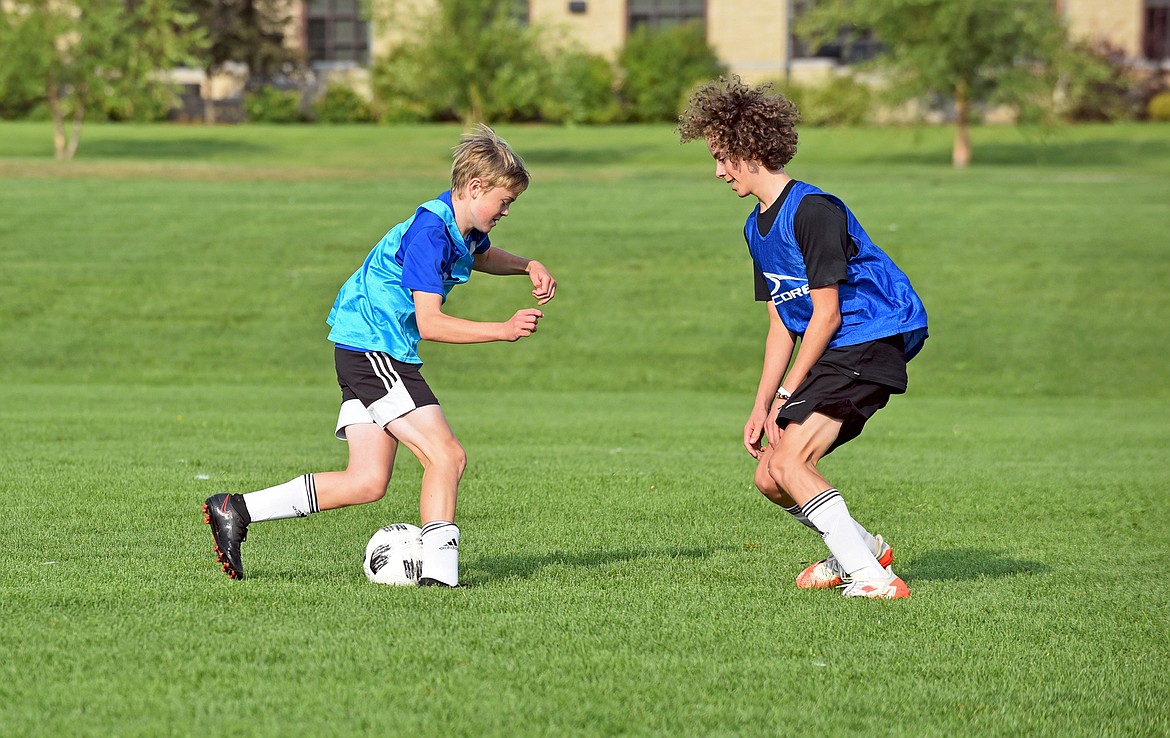 Whitefish freshman Griffin Gunlikson, left, and sophomore Rye Duffy, right, work through a drill at a boys soccer practice at Smith Fields on Thursday. (Whitney England/Whitefish Pilot)