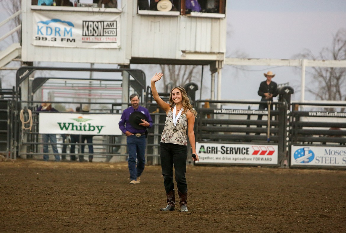 Esther Roeber waves to the crowd after performing the national anthem at the Moses Lake Roundup Saturday night.