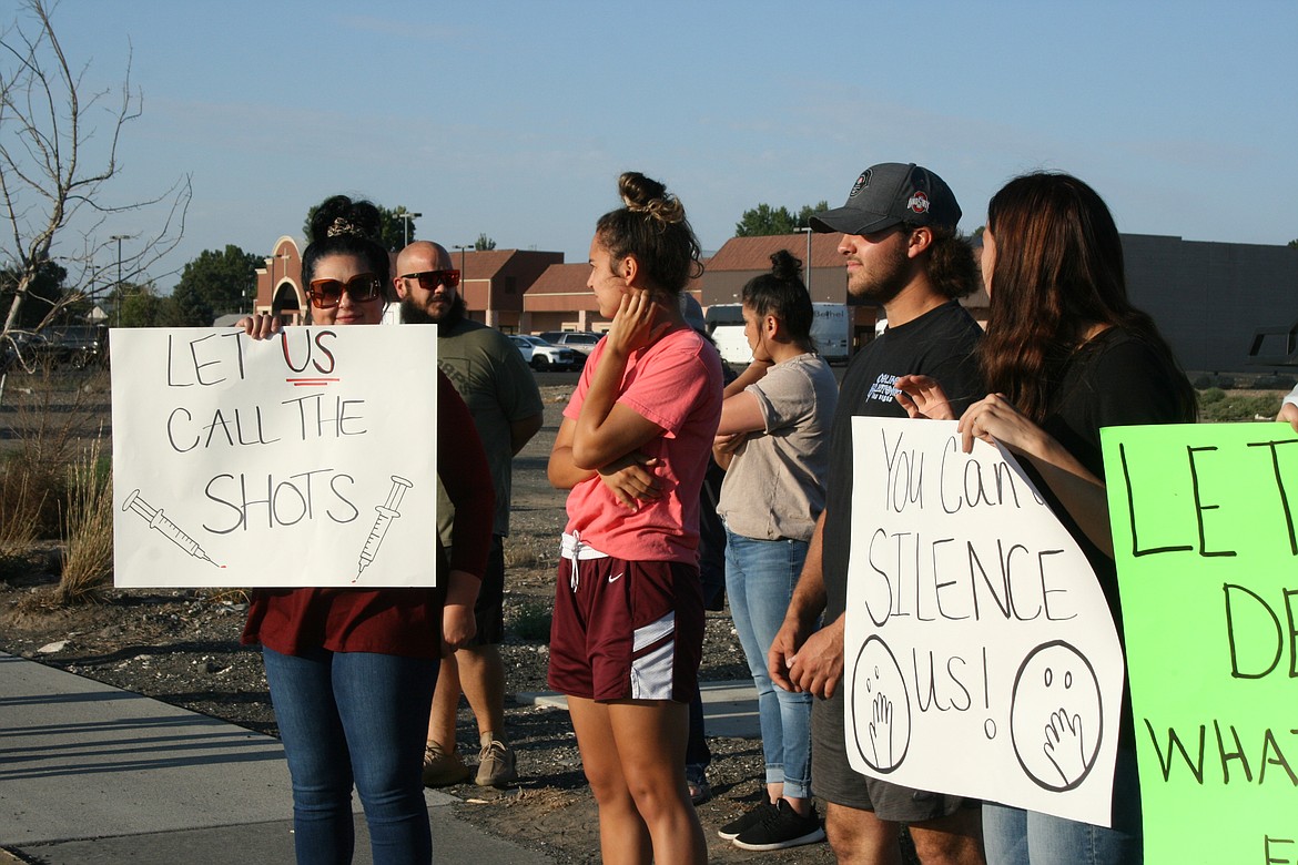 Protesters gathered outside the Othello School District office Monday to protest mandates requiring them to be vaccinated against the COVID-19 virus or risk losing their jobs.