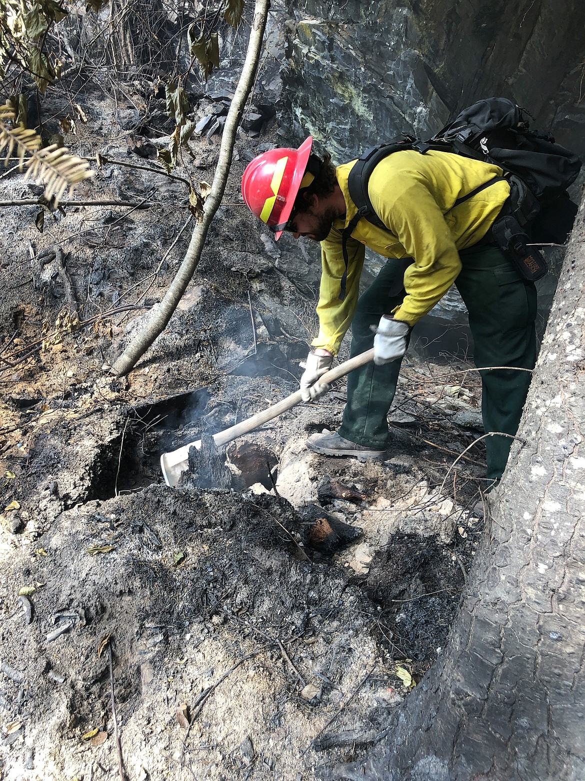 A firefighter working on the Thorne Creek Fire in Sanders County digs out hot spots so they can be extinguished. Lolo National Forest officials said Stage II restrictions would be lifted on Thursday, Aug. 26, 2021. (InciWeb)