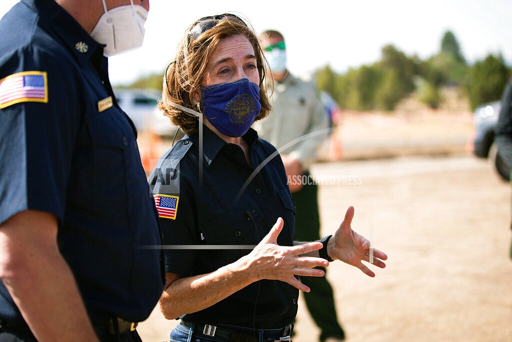 In this June 28, 2021, file photo, Oregon Gov. Kate Brown visits the Bly Fire Camp on the southern edge of the Bootleg Fire, in Klamath County, Ore. People in Oregon, regardless of vaccination status, will be once again be required wear masks in most public outdoor settings, including large outdoor events where physical distancing is not possible, beginning Friday, Aug. 27, 2021. (Arden Barnes/The Herald And News via AP, File)