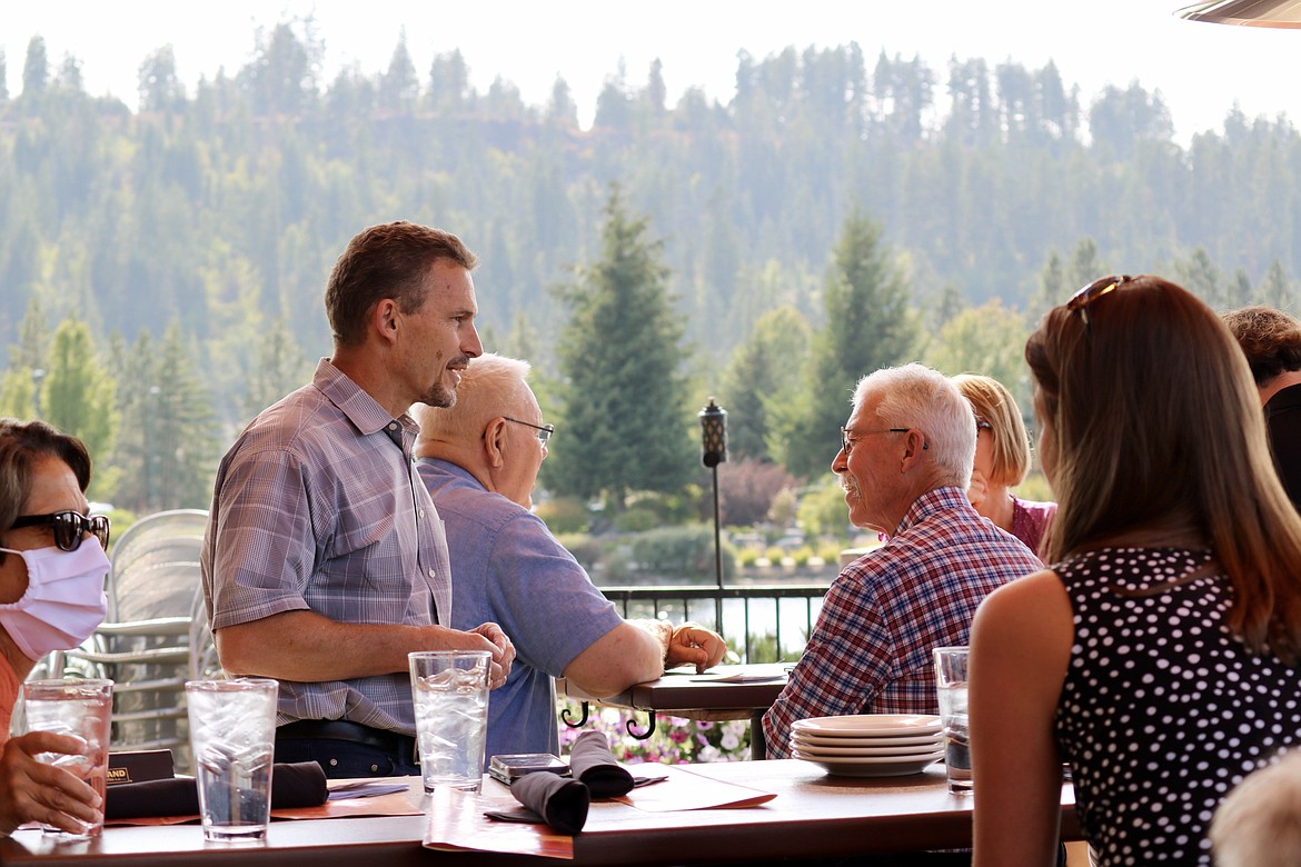 Charles Buck, left standing, talks with U of I Coeur d'Alene colleagues at his going away party at Bardenay Restaurant & Distillery in Riverstone on Wednesday, following a 10-year career with the university. HANNAH NEFF/Press