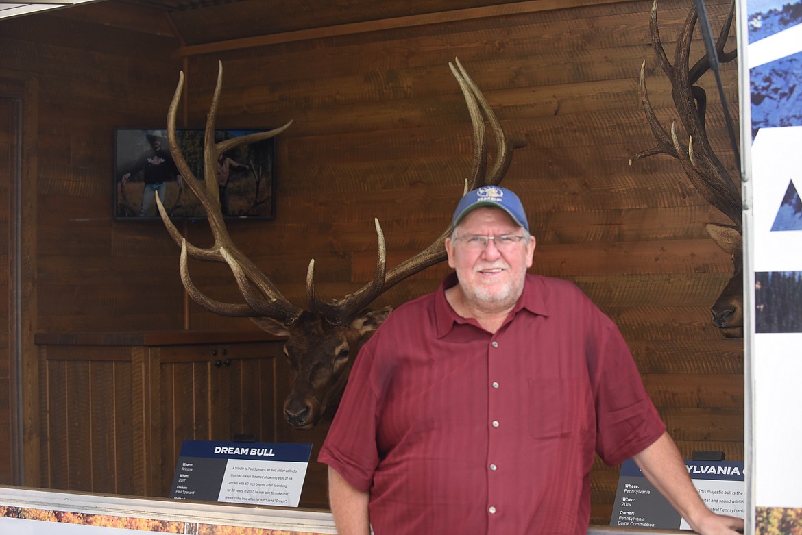 Dave Meehan, of Whitefish, poses beside a bull elk mount in the trailer he pulls as part of the Rocky Mountain Elk Foundation's Great Elk Tour, at the Sportsman and Ski Haus store in Kalispell on Saturday, Aug. 21, 2021. Meehan is the tour manager and an avid elk hunter. (Scott Shindledecker/Daily Inter Lake)