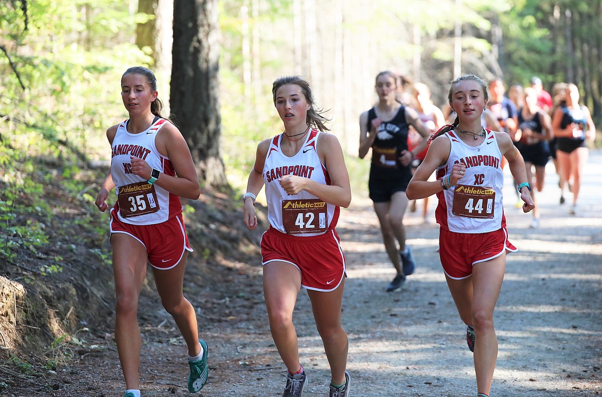 Payton Betz (left), Megan Oulman and Grace Rookey run side-by-side at the start of Friday's dual.