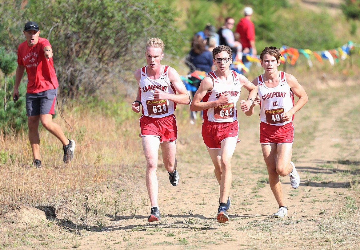 Ben Ricks (left), Nathan Roche and Trey Clark run side-by-side near the halfway point of Friday's dual.