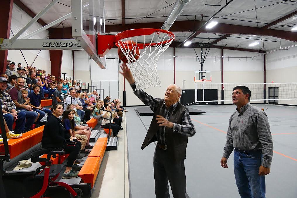 He may be north of 90, but Neptune Lynch was still plenty spry enough to sink a bucket at one of the new gym's lowered baskets as Plains School Superintendent Thom Chisholm and a crowd of celebrants watch during the dedication of the new multi-purpose building last week. (Chuck Bandel/Valley Press)