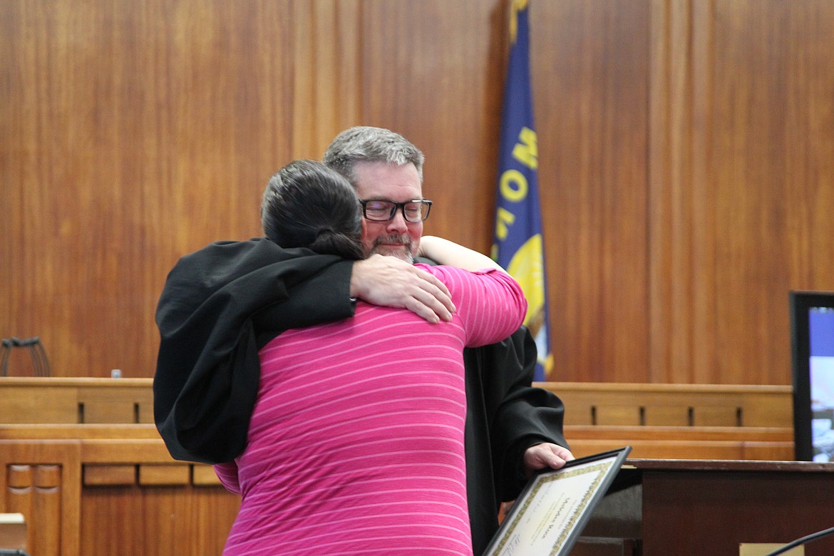 Melodee Rose hugs District Court Judge Matthew Cuffe at the Lincoln County Treatment Court graduation ceremony on Aug. 24. (Will Langhorne/The Western News)