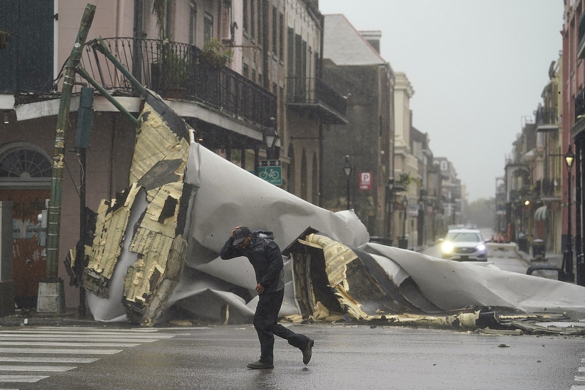 A man passes by a section of roof that was blown off of a building in the French Quarter of New Orleans by Hurricane Ida winds on Sunday, Aug. 29, 2021. (Eric Gay/Associated Press)