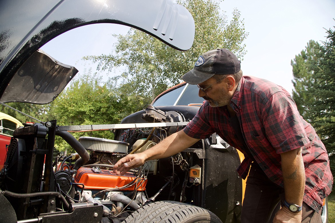 Steve Melkioty opens the font tilt hood on a 1941 Plymouth to reveal the new engine work. (Kay Bjork photo)