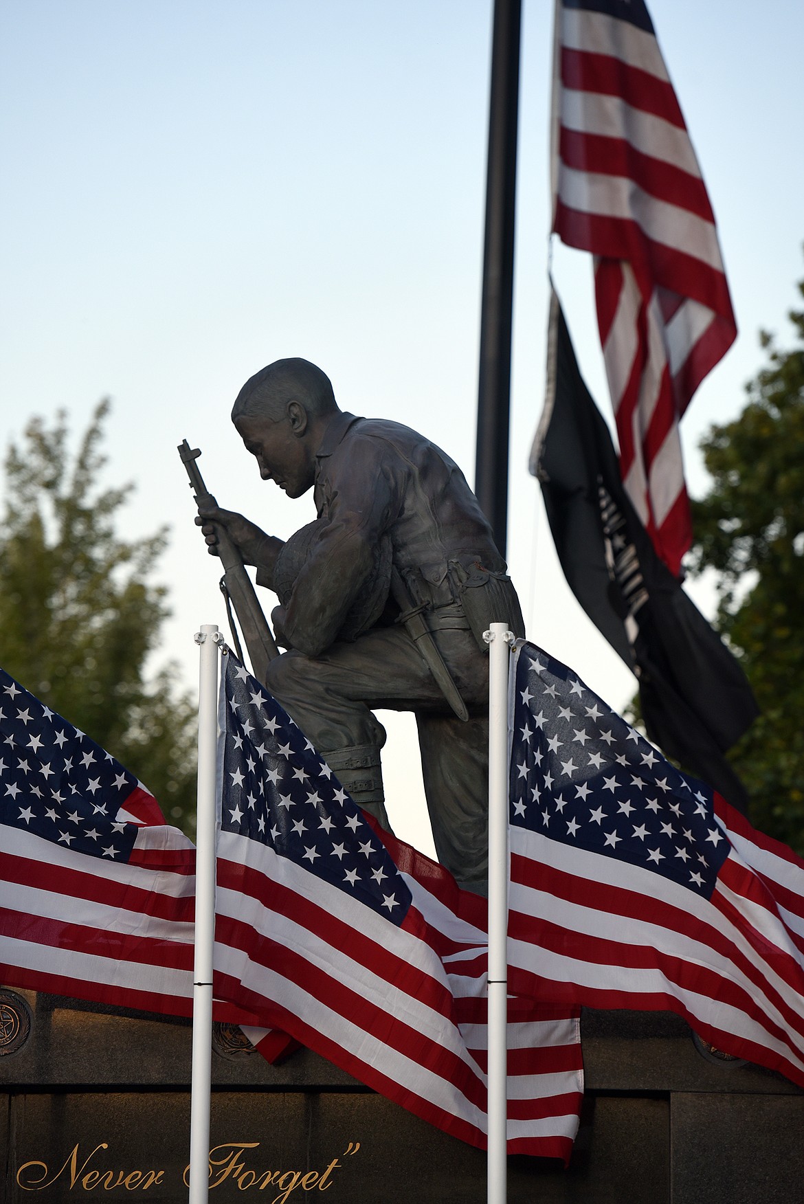 Flags adorn the Flathead County Veterans Memorial in Kalispell's Depot Park on Tuesday, Aug. 31, 2021, shortly before a candlelight vigil was held to honor the 13 U.S. military personnel killed in an Aug. 26 attack outside the Kabul airport in Afghanistan. (Jeremy Weber/Daily Inter Lake)