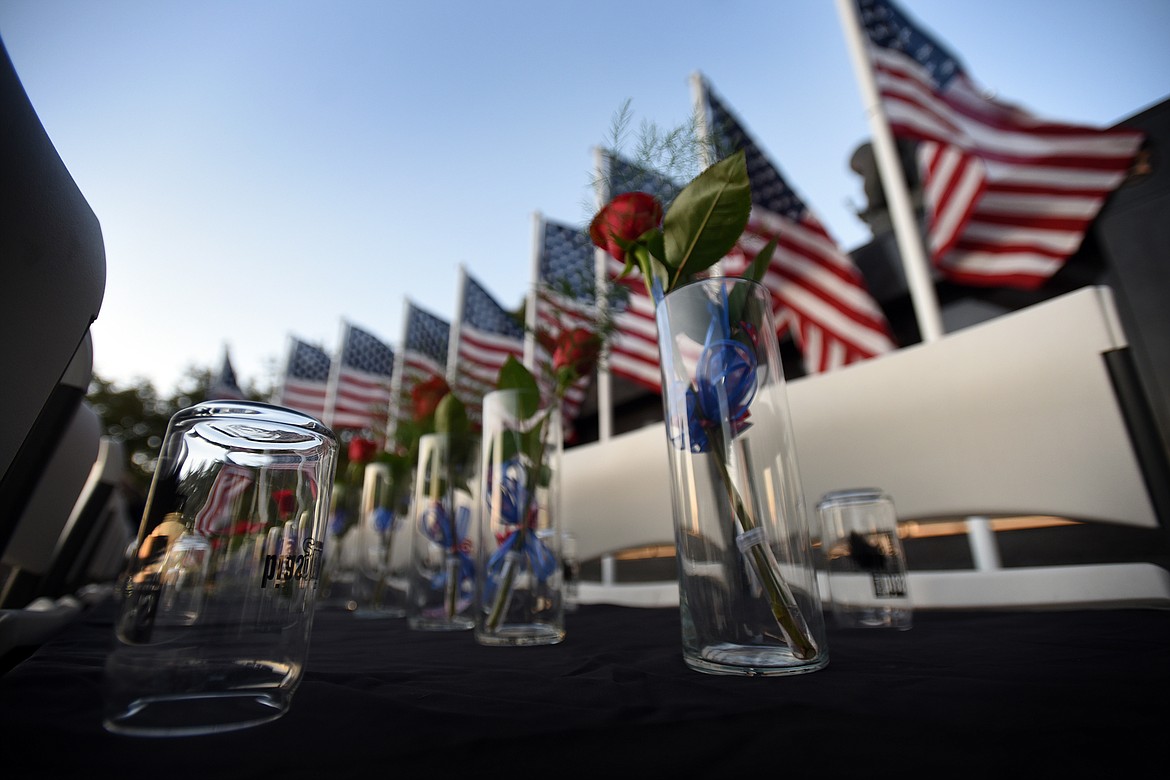 During a candlelight vigil at the Flathead County Veterans Memorial in Kalispell's Depot Park on Tuesday, Aug. 31, 2021, 13 roses, glasses and chairs symbolize the 13 U.S. military personnel lost in an Aug. 26 attack outside the Kabul airport in Afghanistan. (Jeremy Weber/Daily Inter Lake)