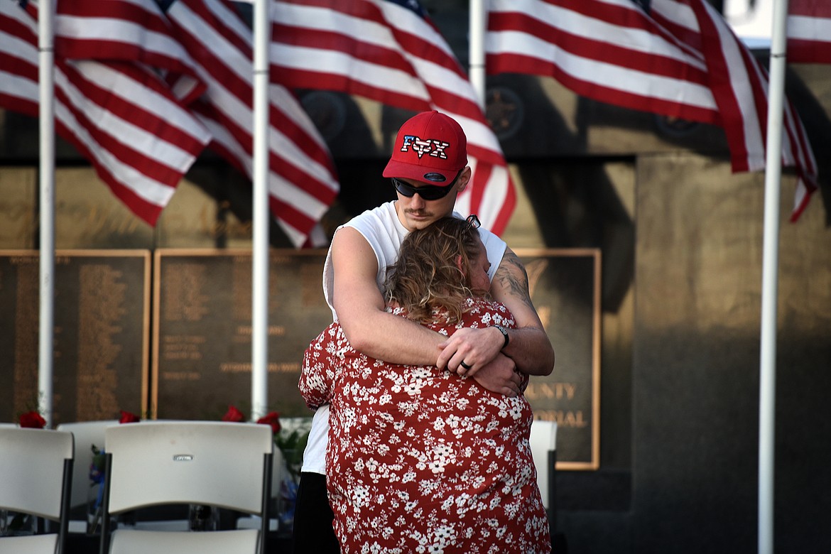 U.S. Army Reserve veteran Kevin Bryant, who served in Afghanistan, hugs Stacy Lorenz in front of the Flathead County Veterans Memorial in Kalispell's Depot Park on Tuesday, Aug. 31, 2021. Dozens gathered at the memorial for a candlelight vigil to honor the 13 U.S. military personnel killed in an Aug. 26 attack outside the Kabul airport in Afghanistan. (Jeremy Weber/Daily Inter Lake)