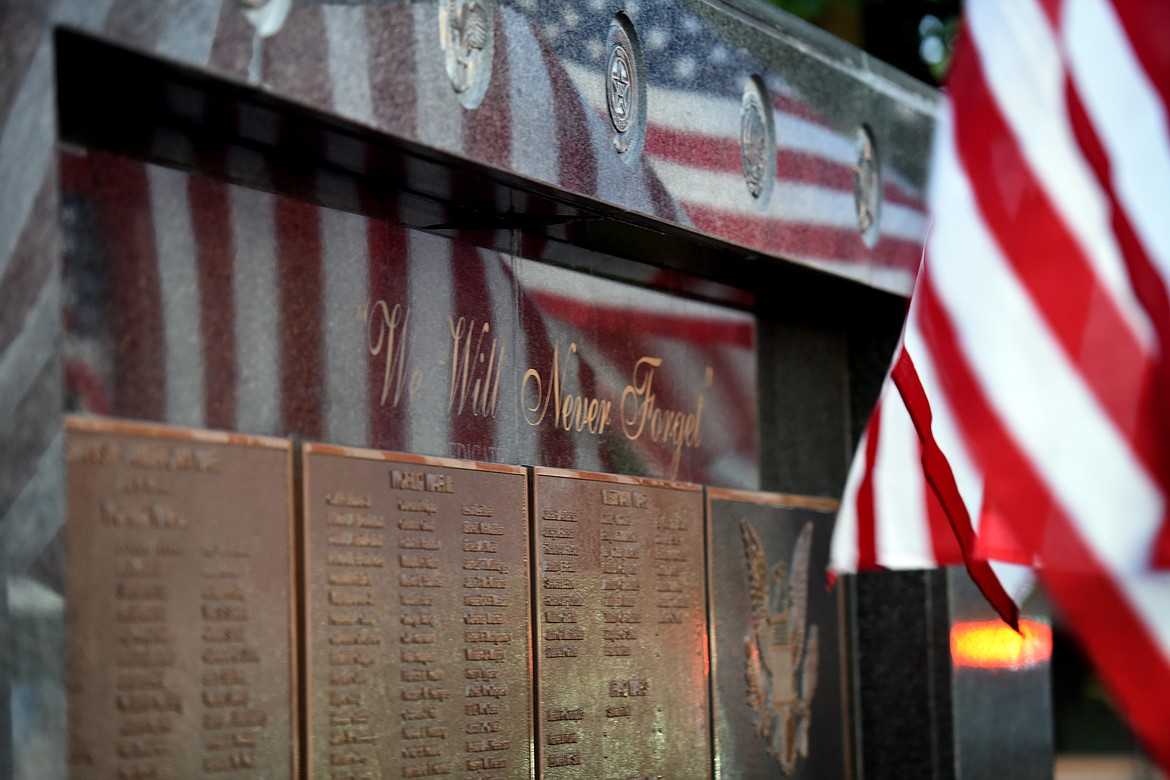The Flathead County Veterans Memorial shows the reflections of flags in Kalispell's Depot Park on Tuesday, Aug. 31, 2021, shortly before a candlelight vigil was held to honor the 13 U.S. military personnel killed in an Aug. 26 attack outside the Kabul airport in Afghanistan. (Jeremy Weber/Daily Inter Lake)