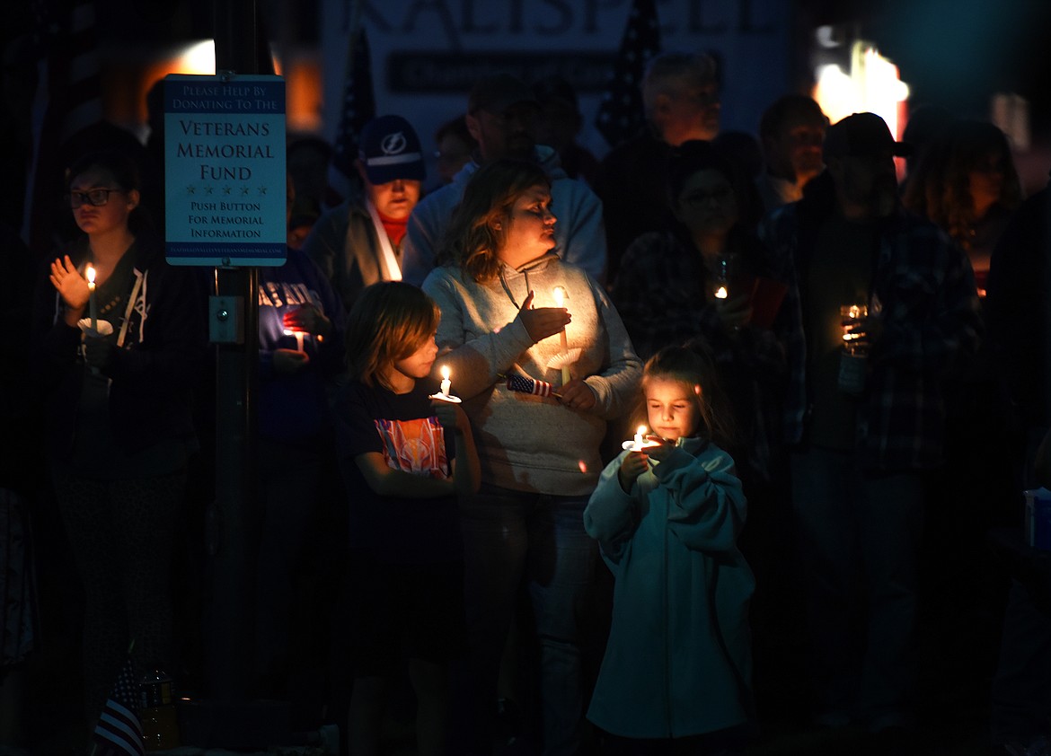 Kyrie Small, middle, Kaden Jones, left, and Alexis Jones keep their candles lit in the Flathead County Veterans Memorial in Kalispell's Depot Park on Tuesday, Aug. 31, 2021, during a vigil to honor the 13 U.S. military personnel killed in an Aug. 26 attack outside the Kabul airport in Afghanistan. (Jeremy Weber/Daily Inter Lake)