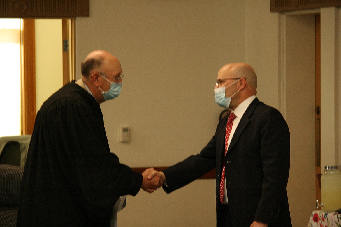 Grant County Superior Court Judge John Knodell (left) shakes hands with new Grant County District Court Judge Nick Wallace (right) after Wallace was sworn in Monday.