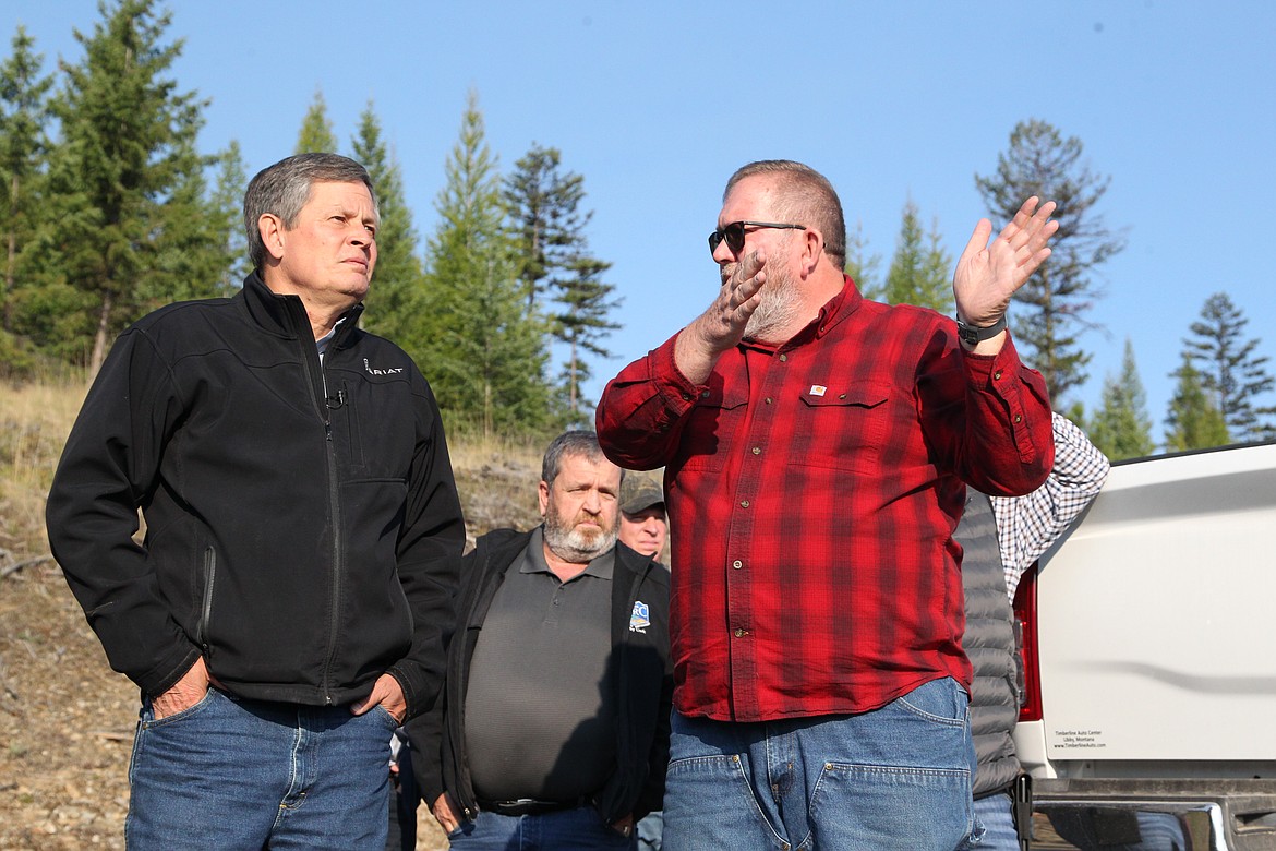 U.S. Sen. Steve Daines, left, and Mark Peck, shared stewardship coordinator with the Lincoln County Port Authority, look out over forest management projects near Libby from a vantage point on Panoramic View Drive on Aug. 30. (Will Langhorne/The Western News)