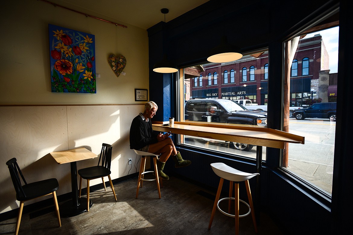 Lynn Luna enjoys a beverage as she checks her phone inside a new expanded seating area at Ceres Bakery in Kalispell on Wednesday, Sept. 1, 2021. (Casey Kreider/Daily Inter Lake)