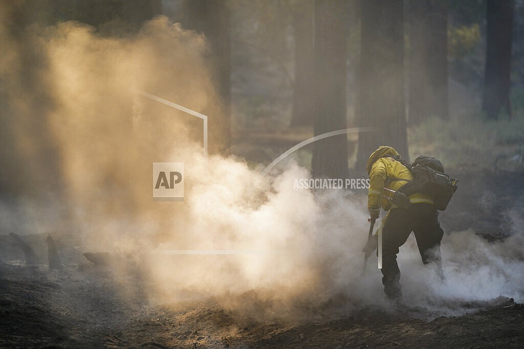 A firefighter mops up hot spots near South Lake Tahoe, Calif., Wednesday, Sept. 1, 2021. Authorities are reporting progress in the battle to save communities on the south end of Lake Tahoe from a huge forest fire. (AP Photo/Jae C. Hong)