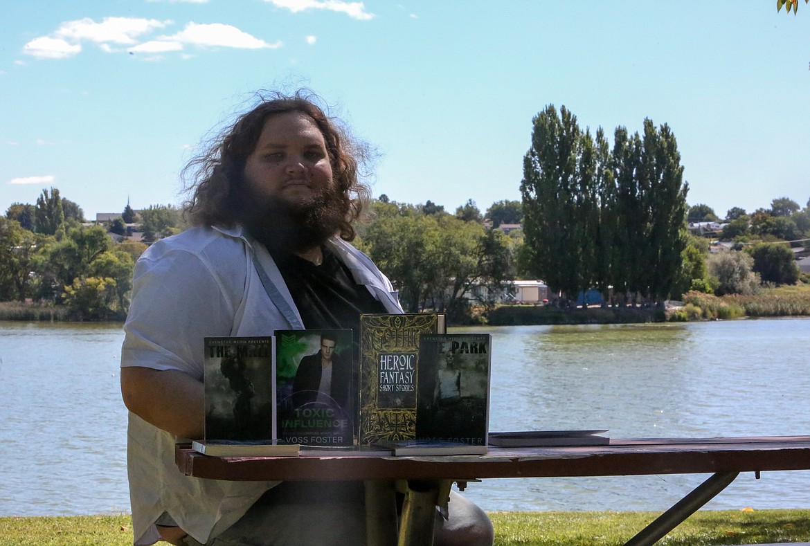 Voss Foster sits at a picnic table with a collection of his published works in front of him at McCosh Park in Moses Lake on Tuesday afternoon.