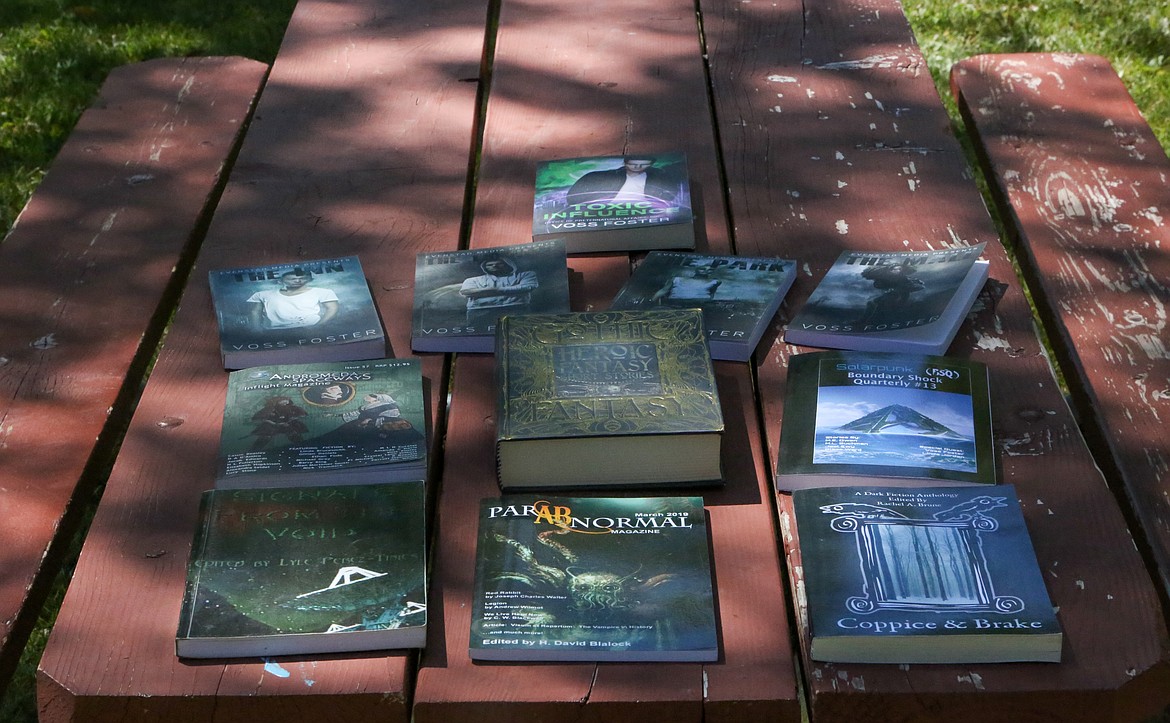 A collection of novels by Voss Foster and anthologies featuring his work sit on a picnic table at McCosh Park in Moses Lake.